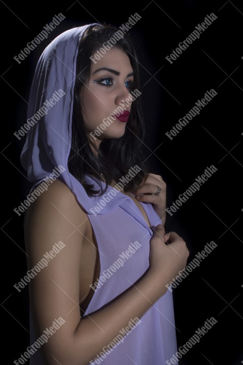 Fashion model posing in studio wearing purple dress