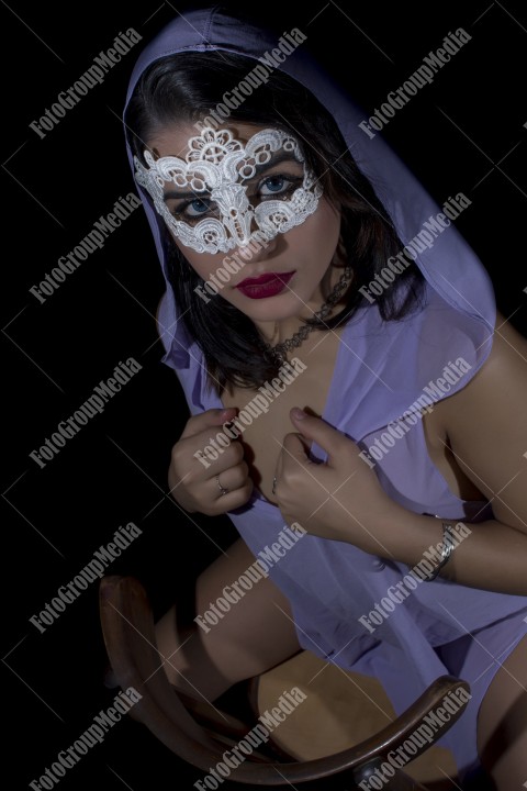 Masked young woman posing in studio, black background