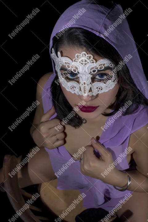 Masked young woman posing in studio, black background