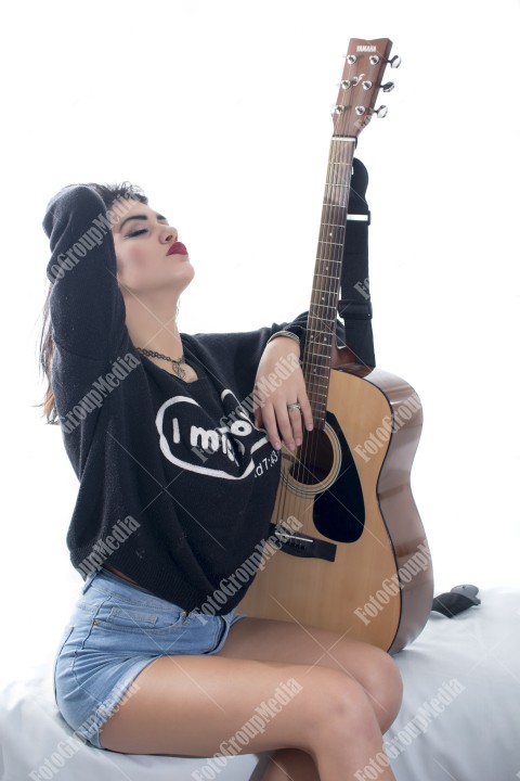 Brunette young girl and guitar, studio shoot