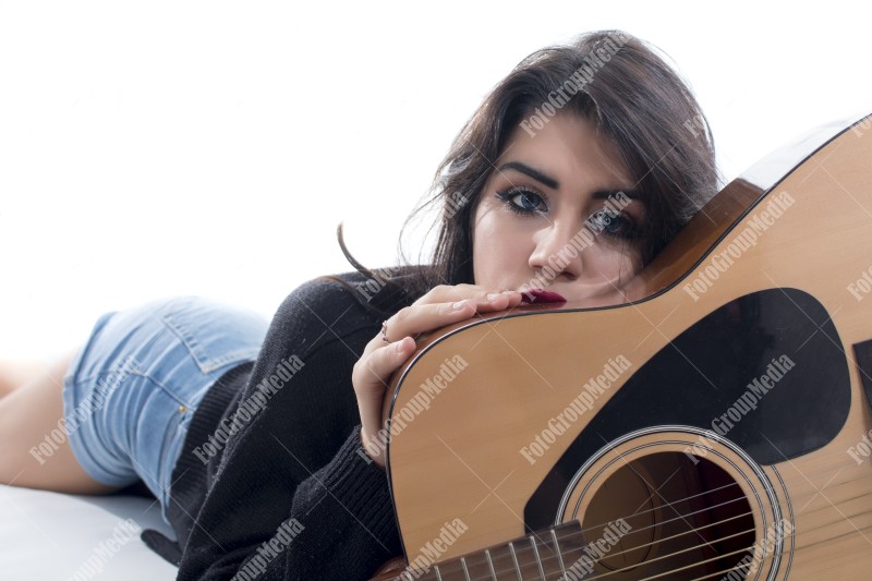 Brunette young girl and guitar, studio shoot