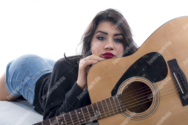 Brunette young girl and guitar, studio shoot