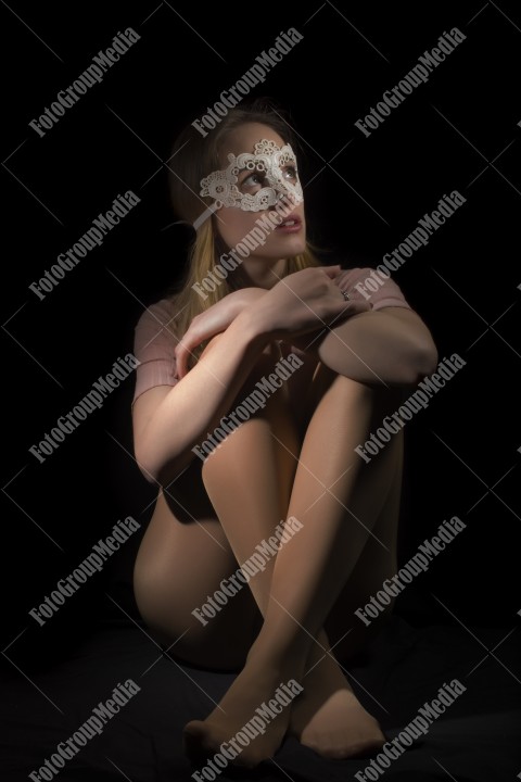 Teenage girl wearing lace mask on black background