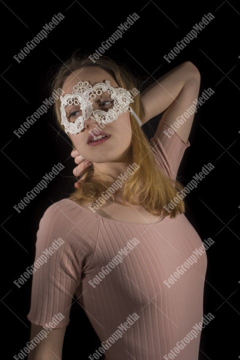 Young attractive woman in mask over black background, lingerie