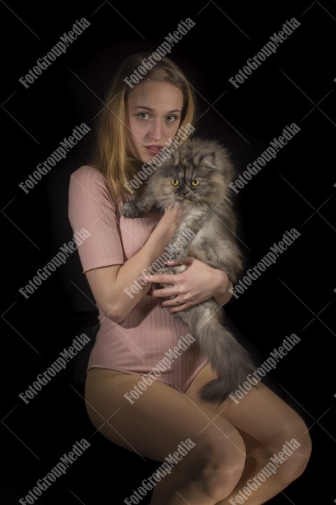 Young girl with cat on black background