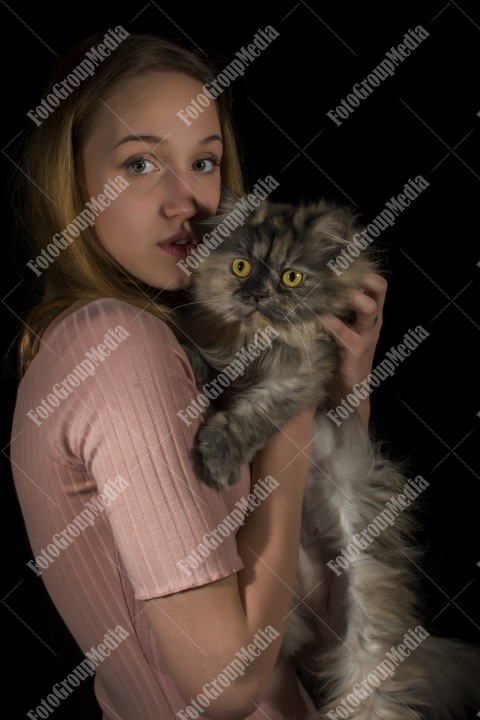 Young woman posing with her fluffy cat for camera