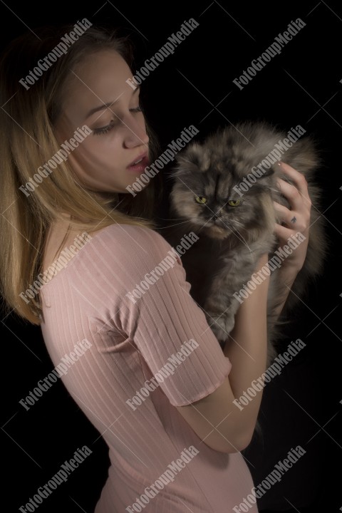 Young woman posing with her fluffy cat for camera