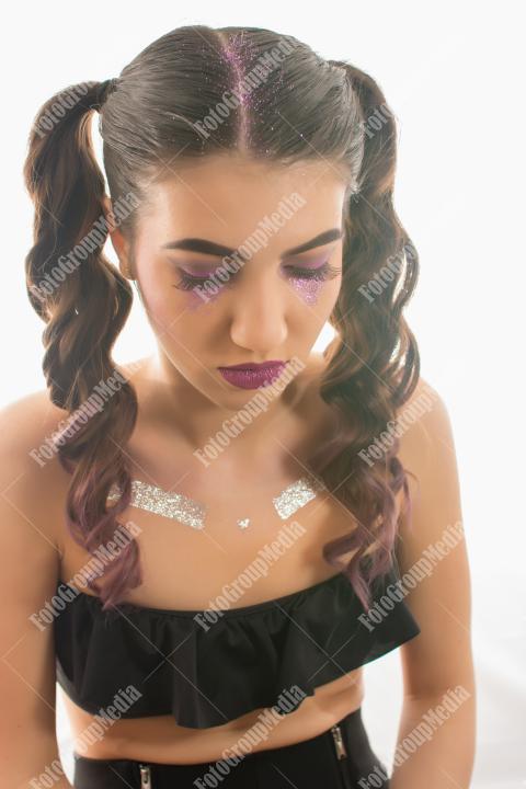 Young woman adorned with shimmering glitter and captivating makeup