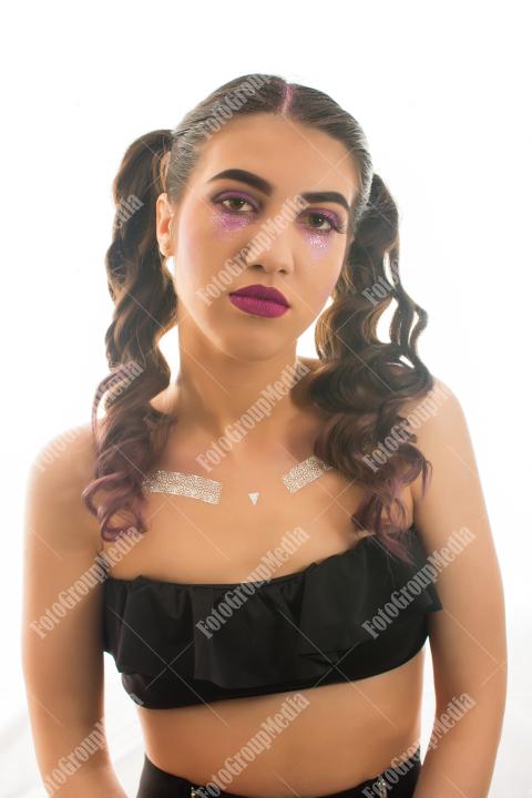 Young woman adorned with shimmering glitter and captivating makeup