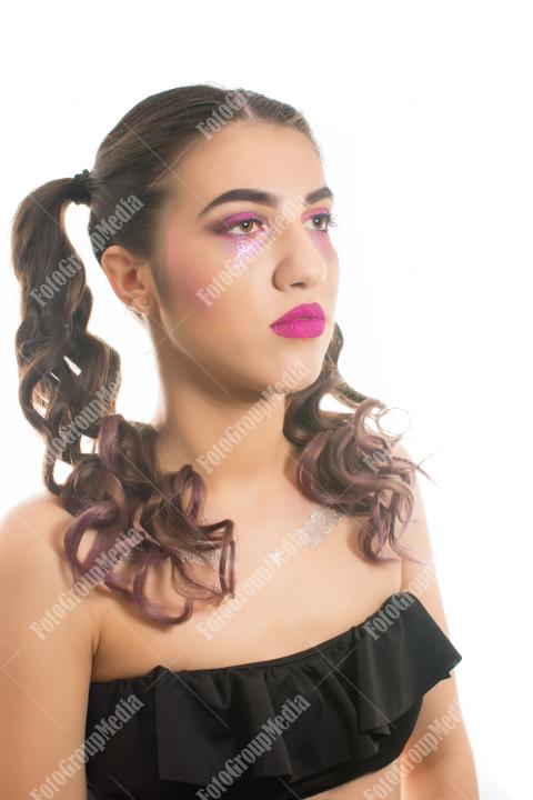 Young woman adorned with shimmering glitter and captivating makeup