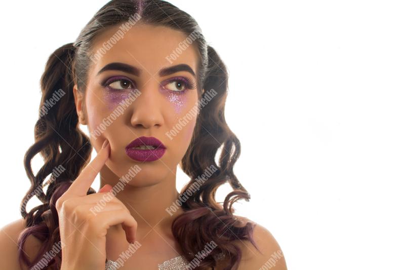 Young girl with two pony tails and artistic make up on white background