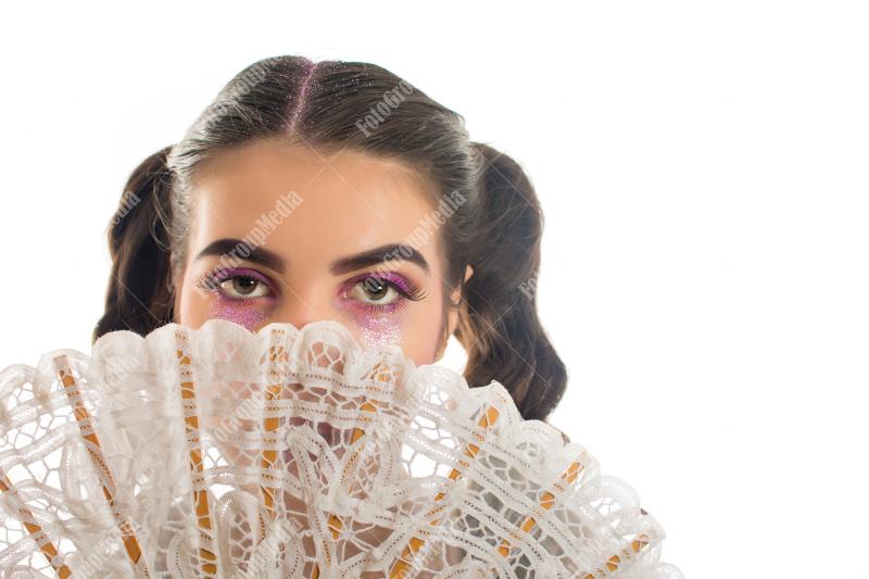 Young girl with artistic make up and lace fan