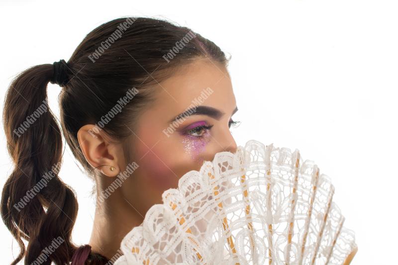 Young girl with artistic make up and lace fan