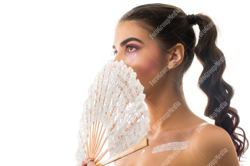 Young girl with artistic make up and lace fan