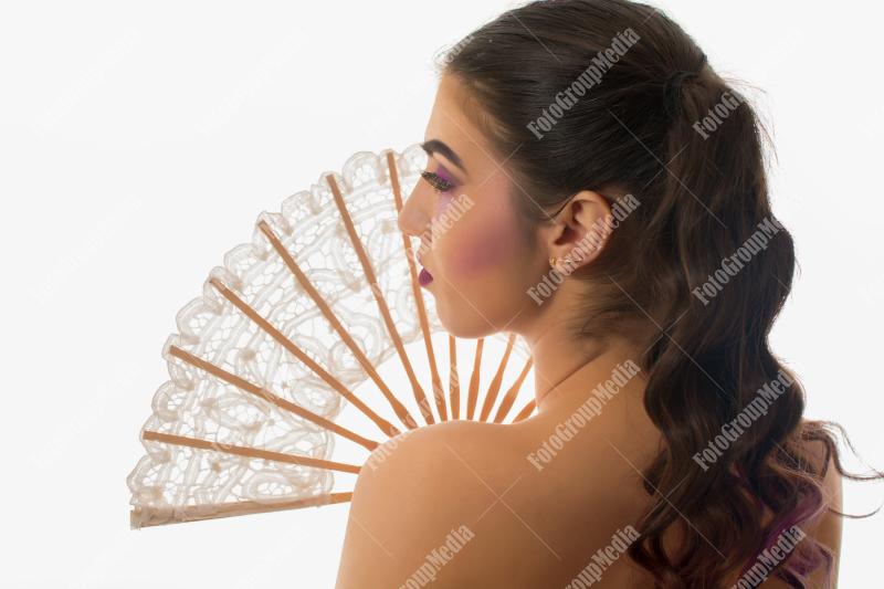 Young girl with artistic make up and lace fan