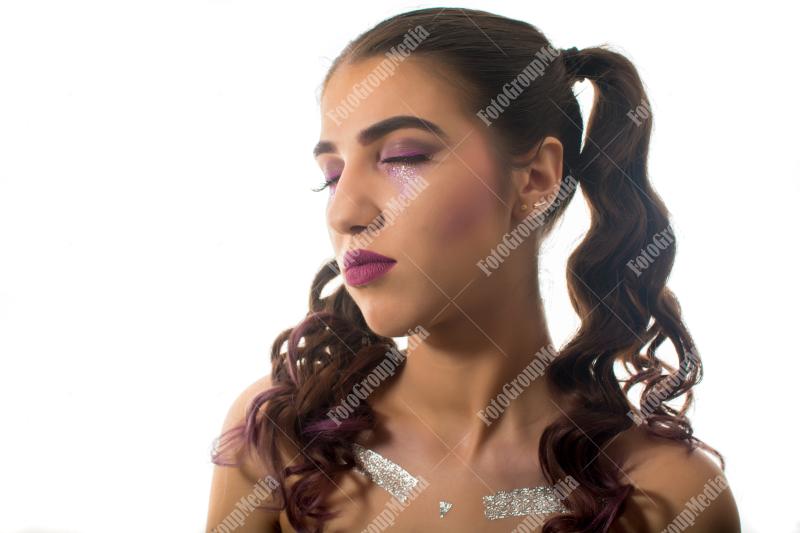 Young woman adorned with shimmering glitter and captivating makeup