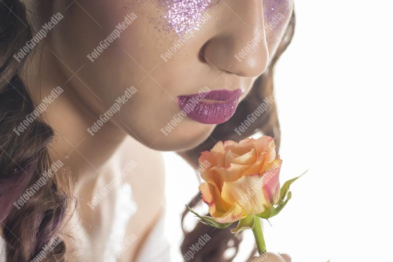 Young girl with artistic make up and yellow rose