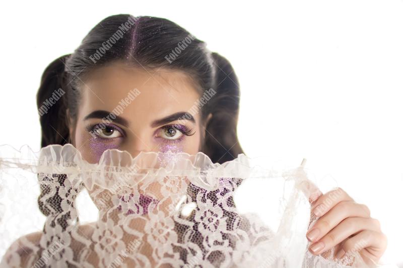 Young girl hiding behind lace umbrella