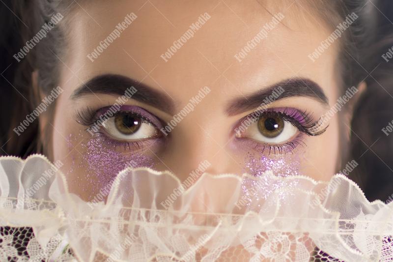 Young girl hiding behind lace umbrella