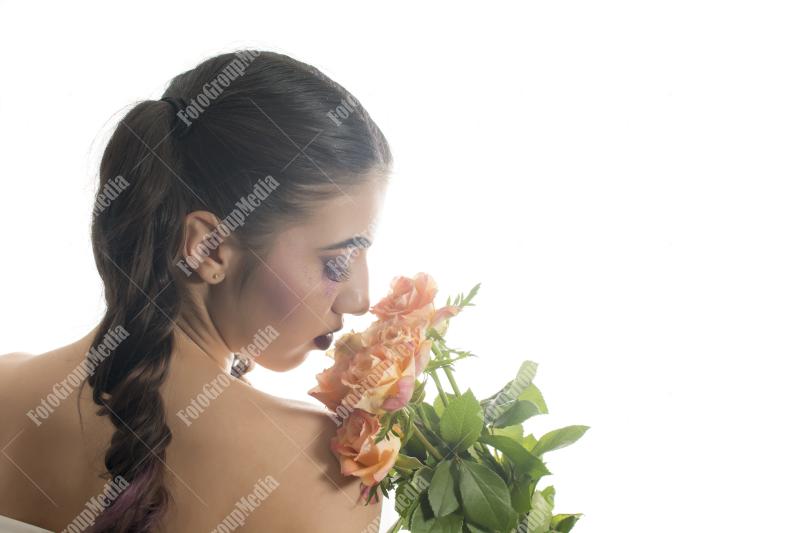 Young girl with artistic make up and yellow roses