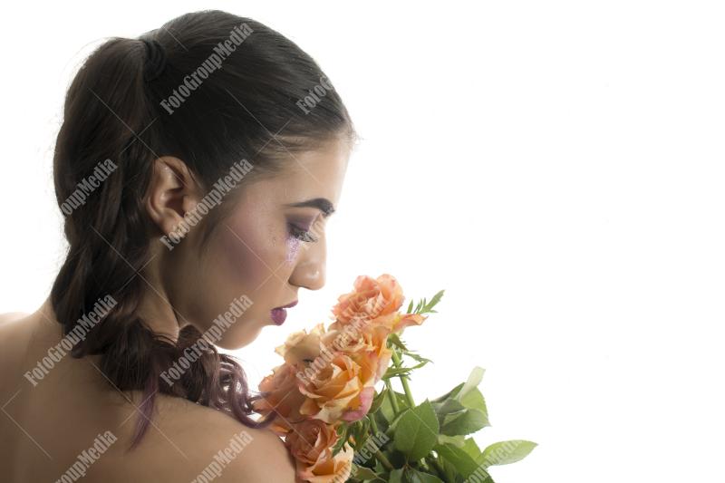 Young girl with artistic make up and yellow roses