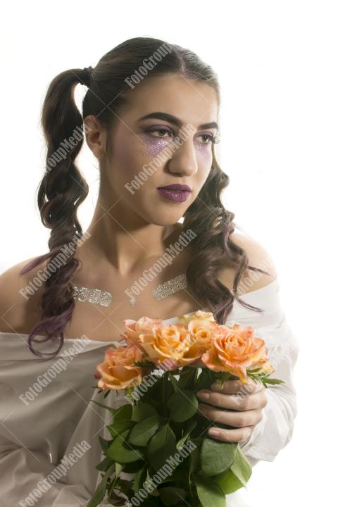 Young girl with artistic make up and yellow roses