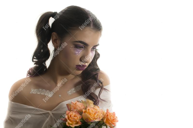 Young girl with artistic make up and yellow roses