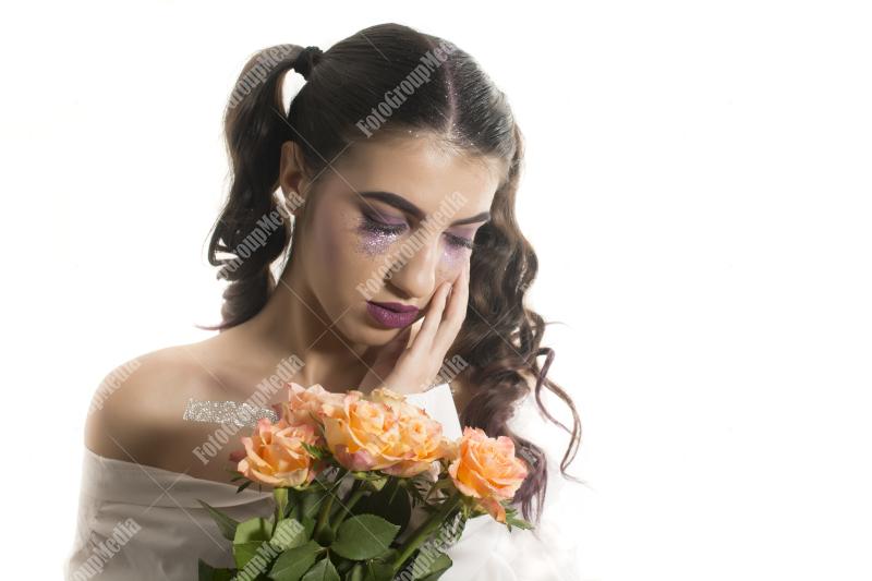 Young girl with artistic make up and yellow roses