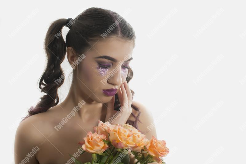 Young girl with artistic make up and yellow roses