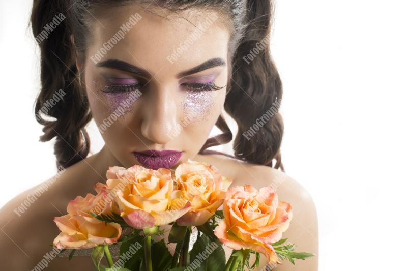 Young girl with artistic make up and yellow roses