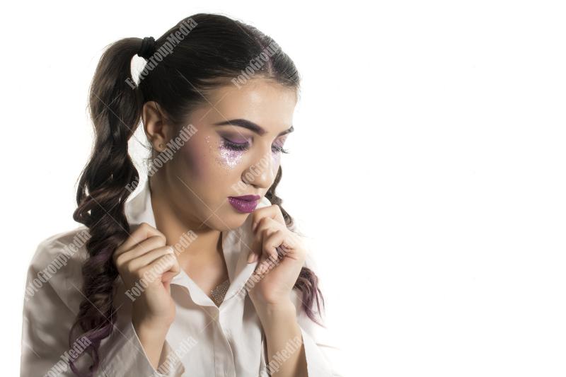 Young girl with two pony tails and artistic make up on white background