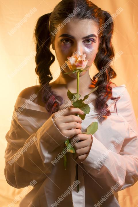 Young woman, yellow rose and artistic make up
