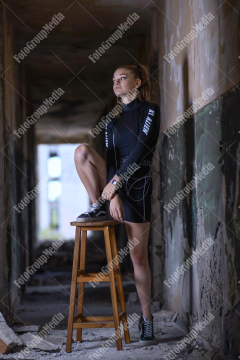 Young girl posing wearing bodysuit in an old building