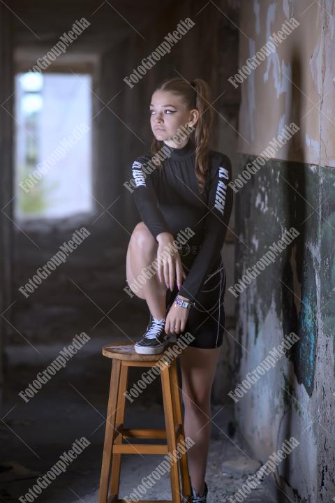 Young girl posing wearing bodysuit in an old building