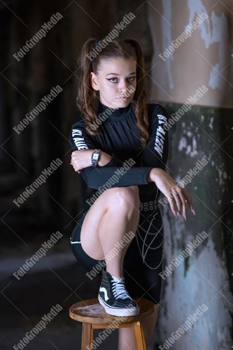 Young girl posing wearing bodysuit in an old building