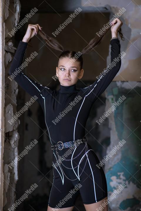 Young woman posing in a tight gym bodysuit in an old building