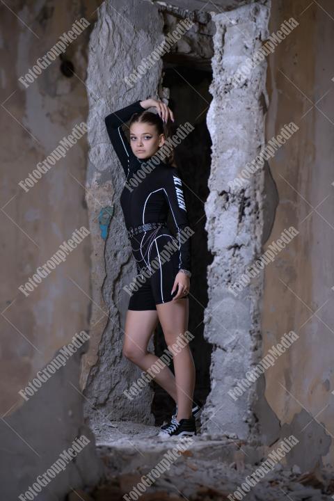 Young woman posing in a tight gym bodysuit in an old building