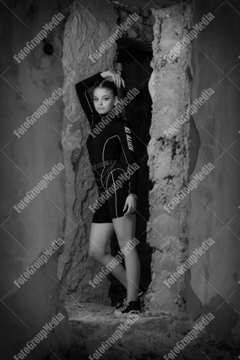 Young woman posing in a tight gym bodysuit in an old building