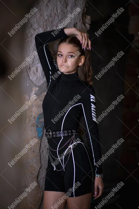 Young woman posing in a tight gym bodysuit in an old building
