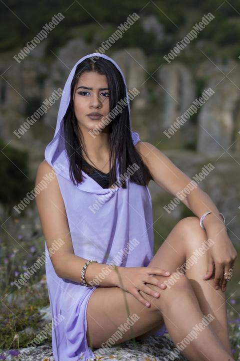 Portrait of a young brunette girl in a field of wild flowers