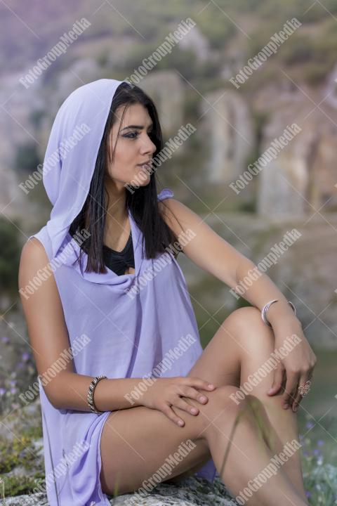 Portrait of a young brunette girl in a field of wild flowers