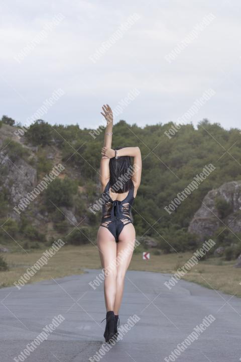 Young girl wearing black bodysuit posing outdoor