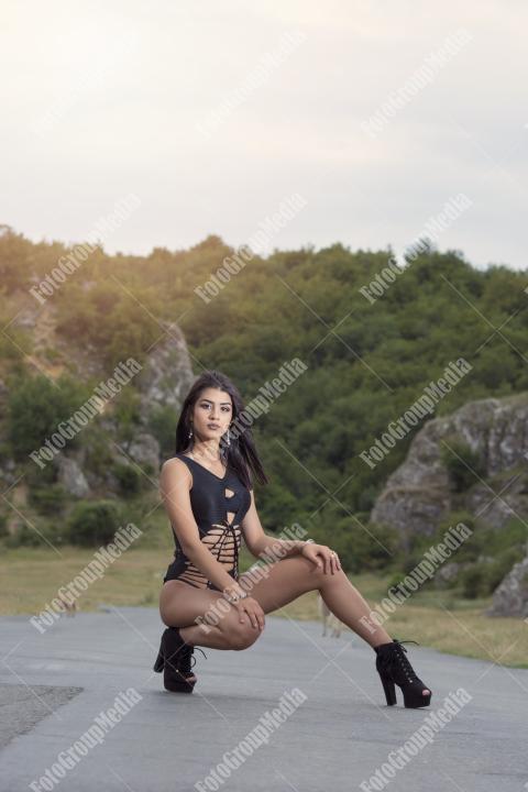 Young girl wearing black bodysuit posing outdoor