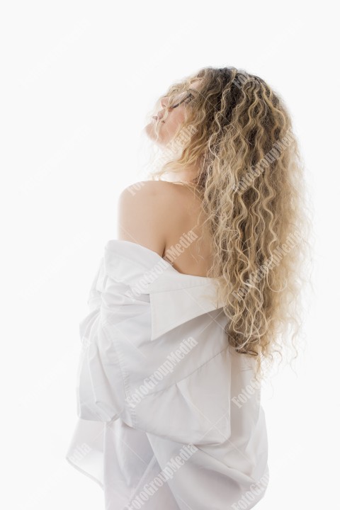 Woman with curly hair and white shirt posing on white background