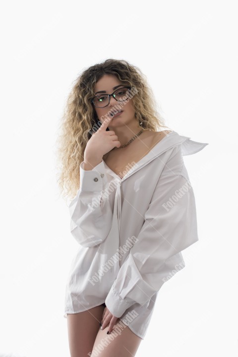 Woman with curly hair and white shirt posing on white background