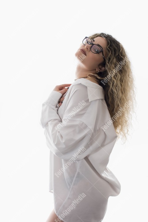Woman with curly hair and white shirt posing on white background