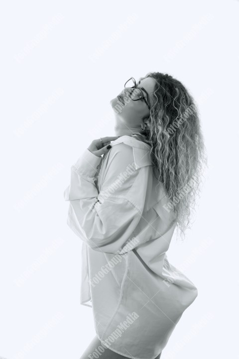 Woman with curly hair and white shirt posing on white background