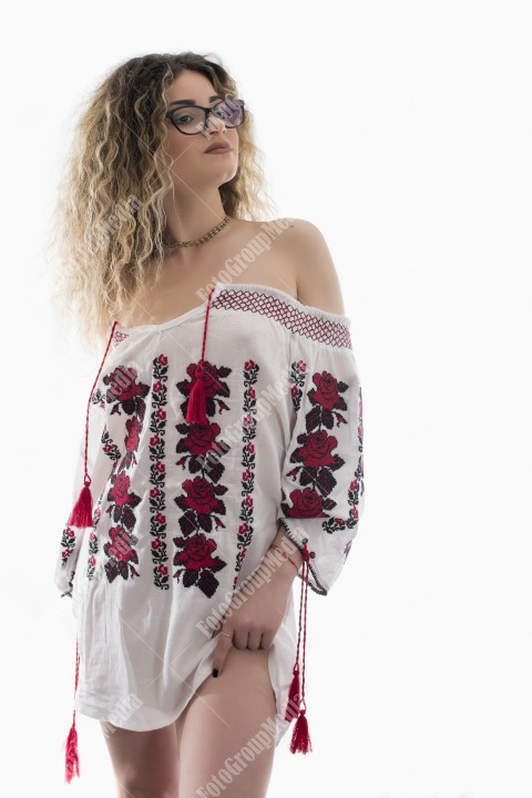 Woman with curly hair and white shirt posing on white background