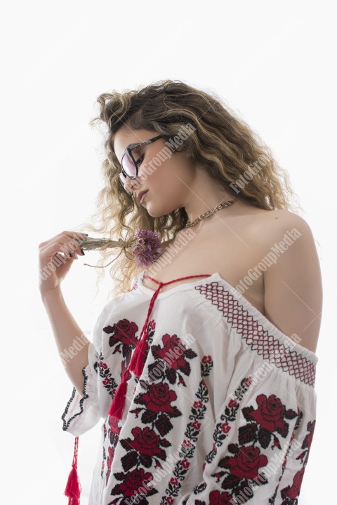 Woman with curly hair and white dress with red flowers posing on white background