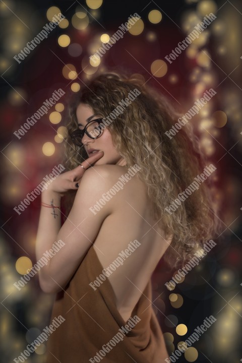 Woman with curly hair wrapped in a scarf posing sexy for camera